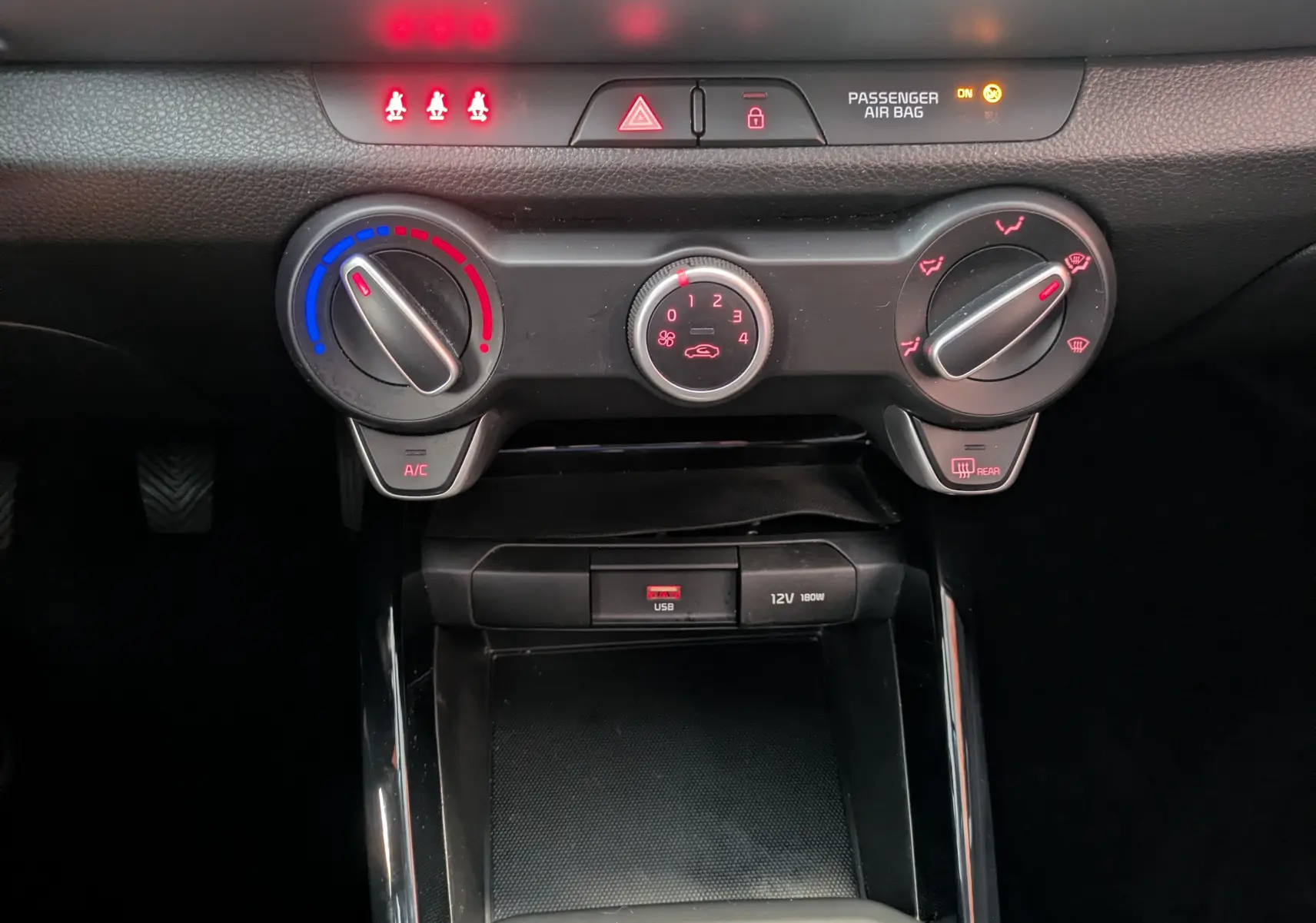 Gros plan sur les commandes de climatisation et la prise USB du tableau de bord du KIA STONIC blanc 2022.