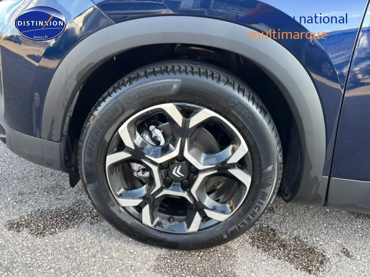 Gros plan sur la roue avant gauche du Citroën C5 Aircross bleu eclipse avec jante alu bicolore.