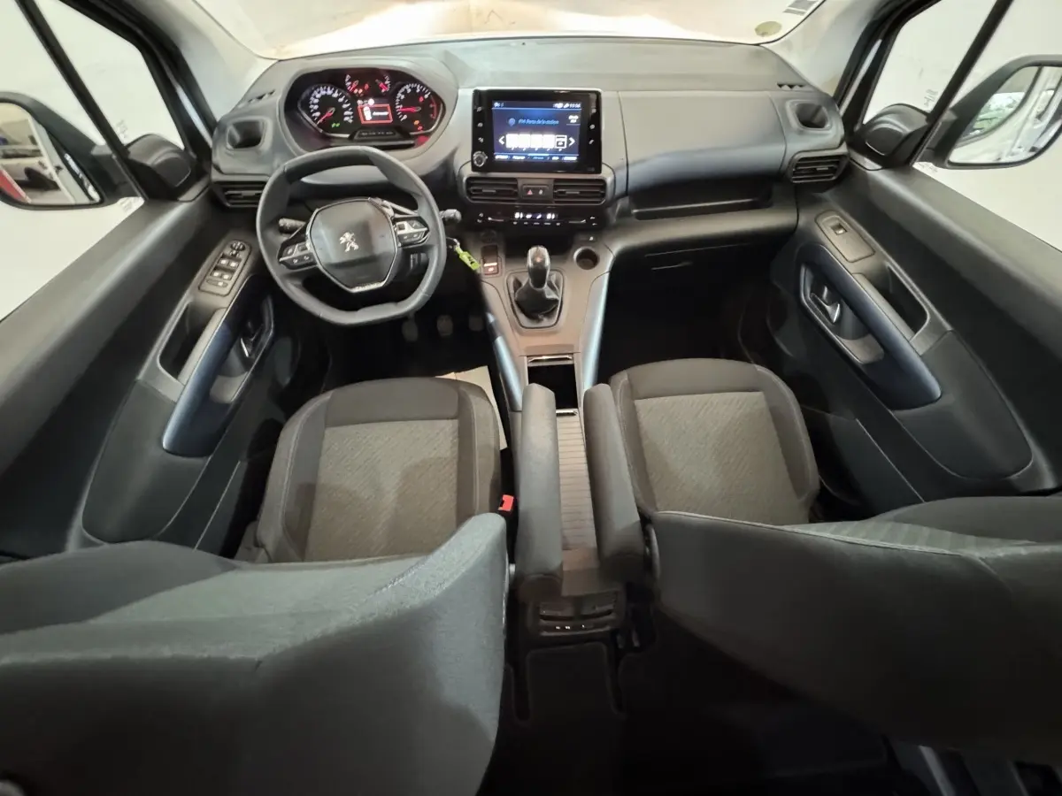 Vue intérieure avant du Peugeot Rifter BlueHDi 100 Allure 2019, tableau de bord noir avec écran tactile central et volant multifonctions.