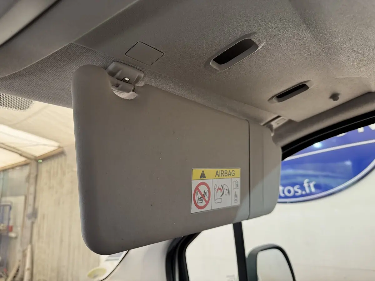 Détail intérieur du pare-soleil côté conducteur du Peugeot Rifter blanc, avec avertissement airbag visible.