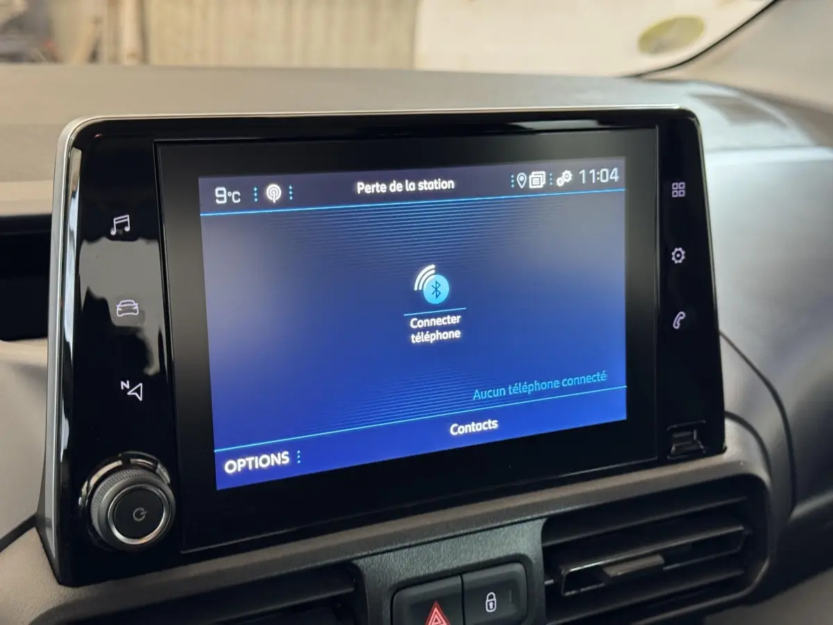 Écran tactile central du tableau de bord du Peugeot Rifter blanc, affichant la connexion Bluetooth téléphone.