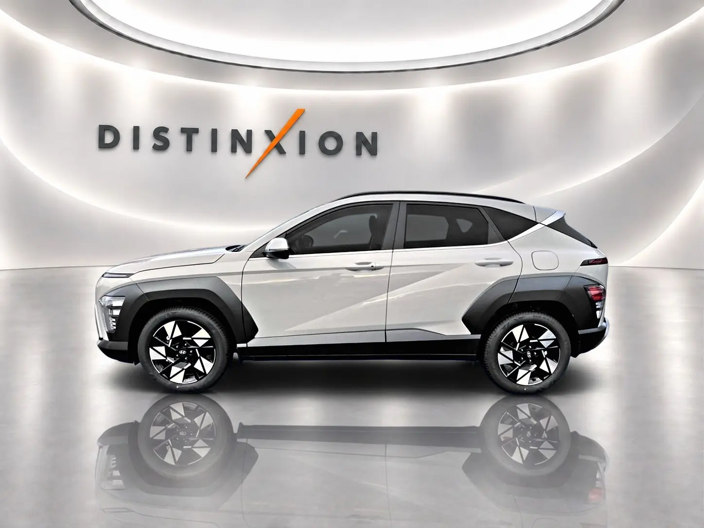 Vue latérale droite d'un Hyundai Kona gris 2025 avec jantes alliage noires et protections d'ailes contrastées.