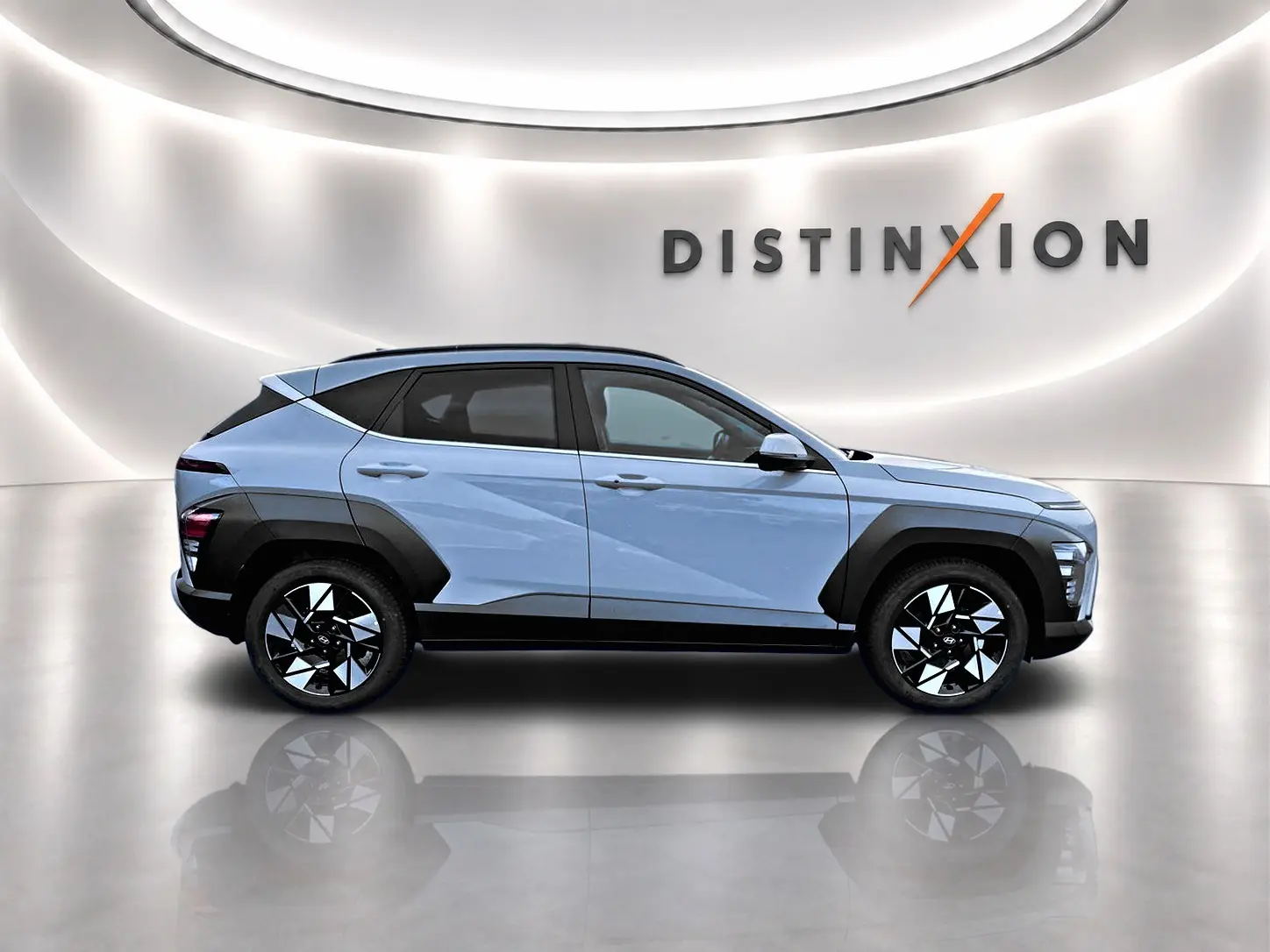 Vue latérale droite du Hyundai Kona gris avec protections noires contrastantes et jantes alliage bicolores.