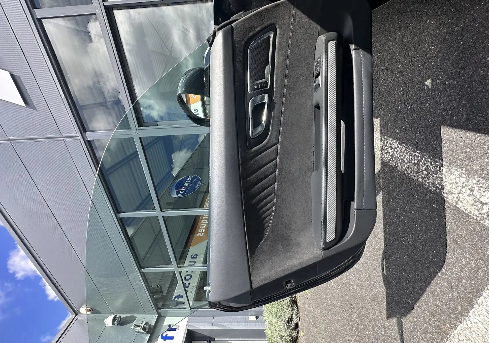 Vue en gros plan de la porte intérieure côté gauche du Mercedes AMG GT 2015 gris foncé avec garniture en alcantara et inserts carbone.