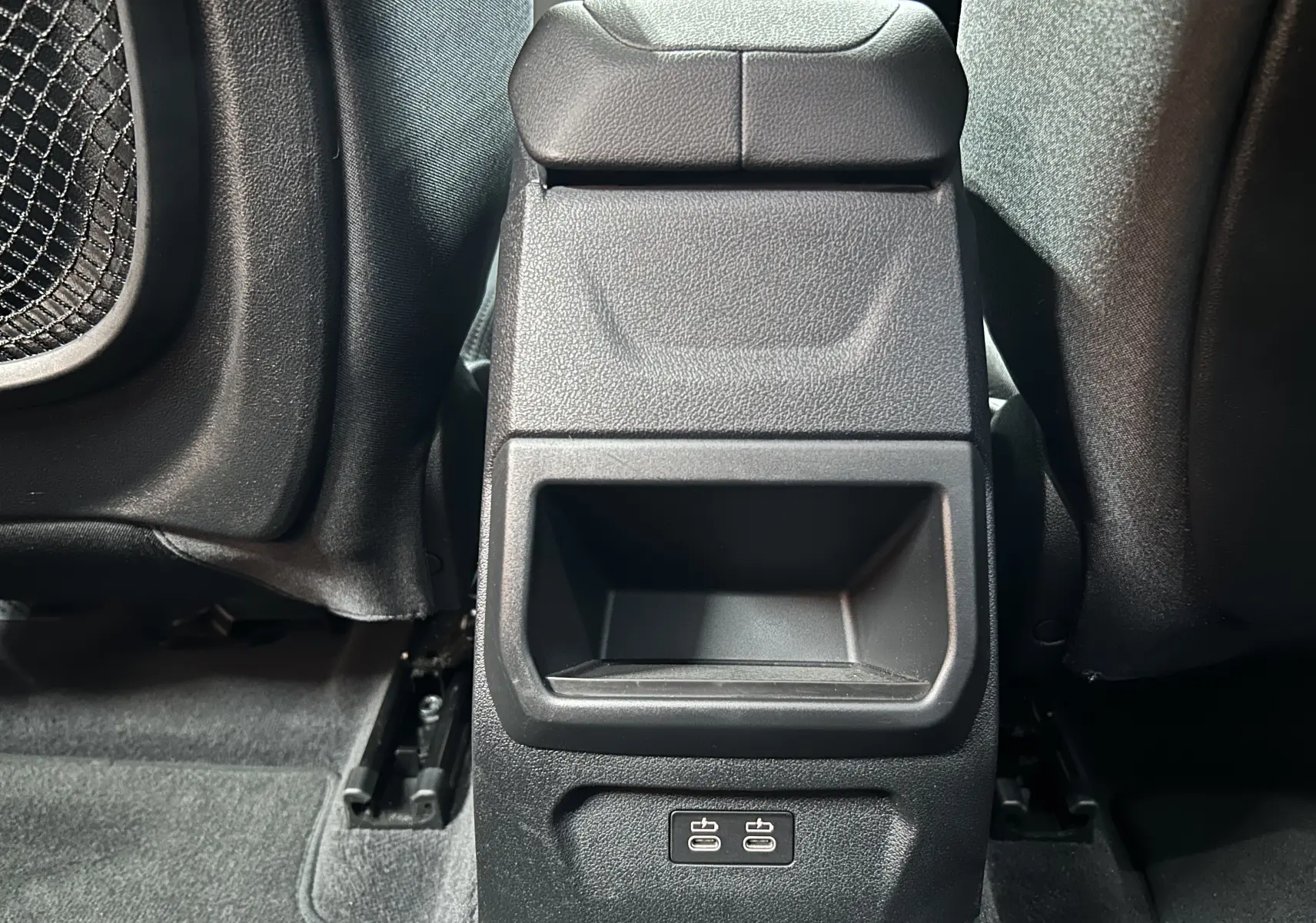Vue rapprochée du rangement central arrière noir avec deux ports USB dans une BMW Série 1 16d 2023.
