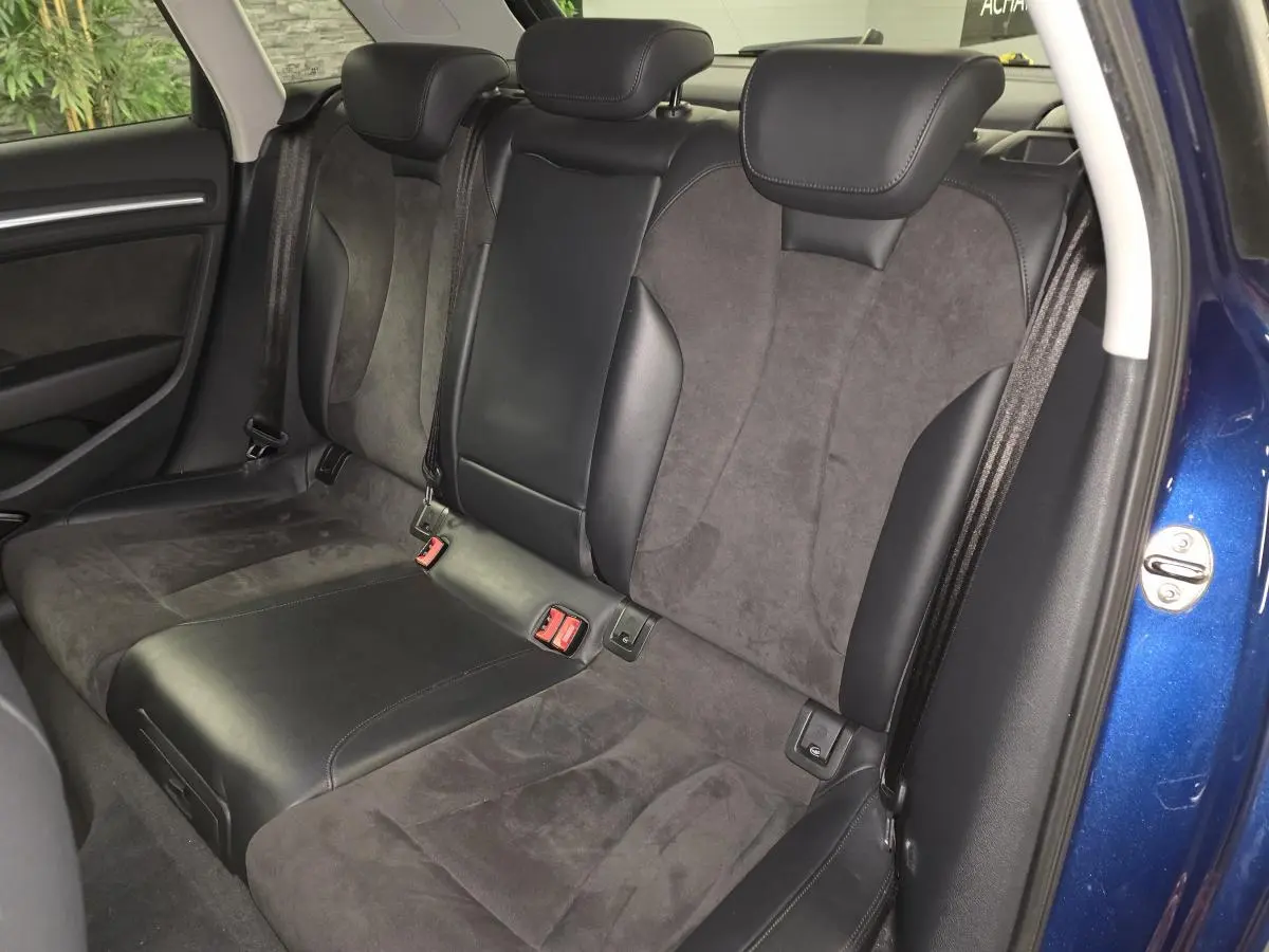 Vue intérieure sur la banquette arrière en alcantara et cuir noir d'une Audi A3 Sportback bleu 2015.