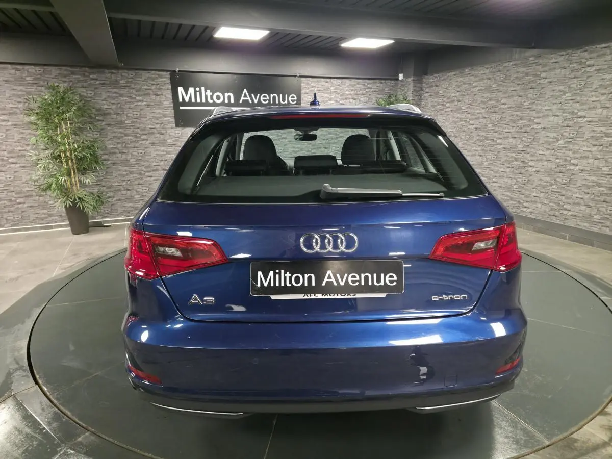 Vue arrière d'une Audi A3 Sportback hybride rechargeable bleu métallisé avec logo e-tron et feux rouges.