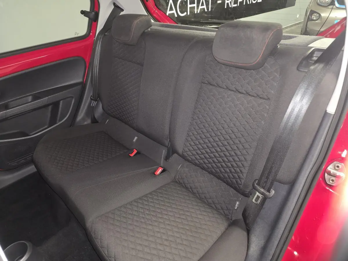 Banquette arrière noire vue côté droit dans une Volkswagen Up rouge 2018 avec ceintures et appuie-têtes intégrés.