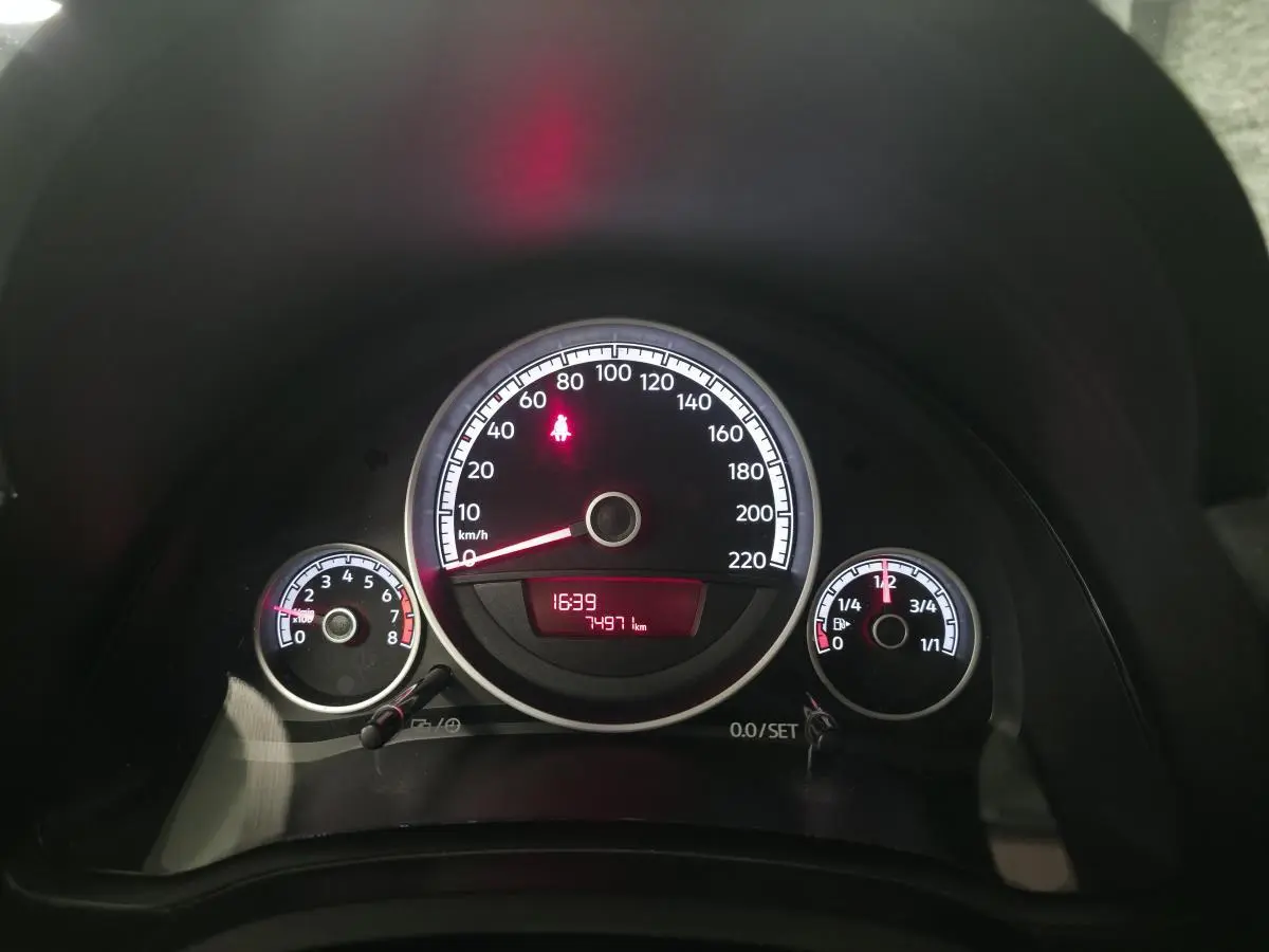 Tableau de bord de Volkswagen UP rouge 2018, vue frontale sur compteurs et affichage numérique rouge.