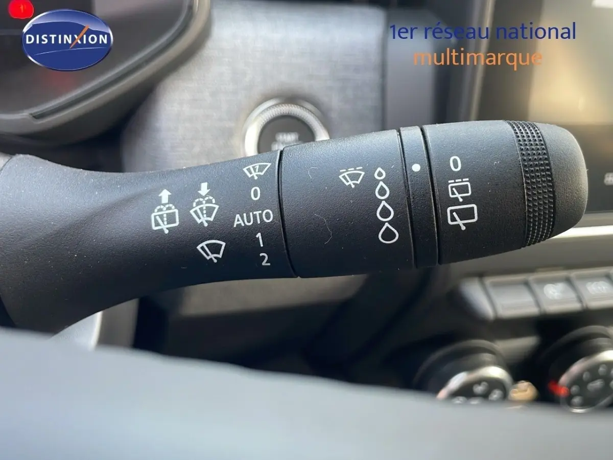 Gros plan sur la manette d’essuie-glace noire avec pictogrammes blancs dans l’habitacle d’une Renault Clio 2025.