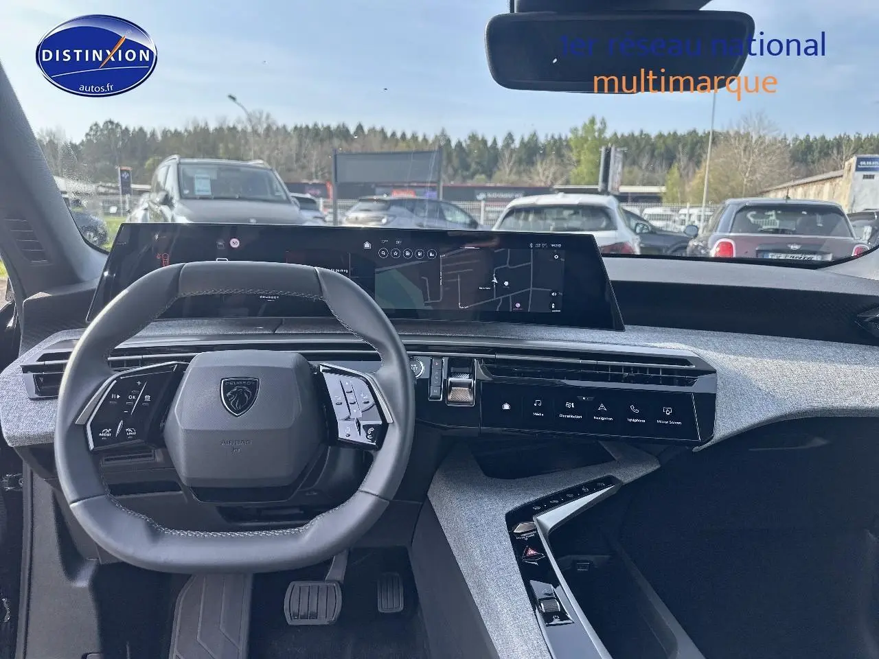 Vue intérieure frontale du tableau de bord et volant cuir multifonction du Peugeot 3008 noir perla nera 2024.