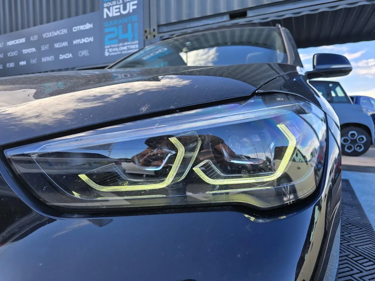 Gros plan sur le phare avant gauche noir saphir métallisé du BMW X1 F48 M Sport 2020 avec éclairage LED distinctif.