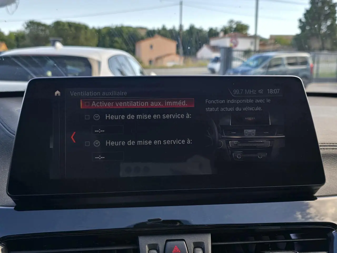 Vue intérieure du tableau de bord du BMW X1 noir, avec écran multimédia affichant les réglages de ventilation.