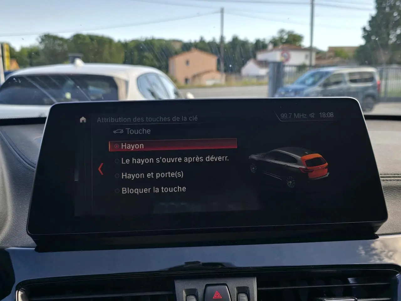 Écran multimédia intérieur BMW X1 affichant les options de verrouillage du hayon, vue du tableau de bord en journée.