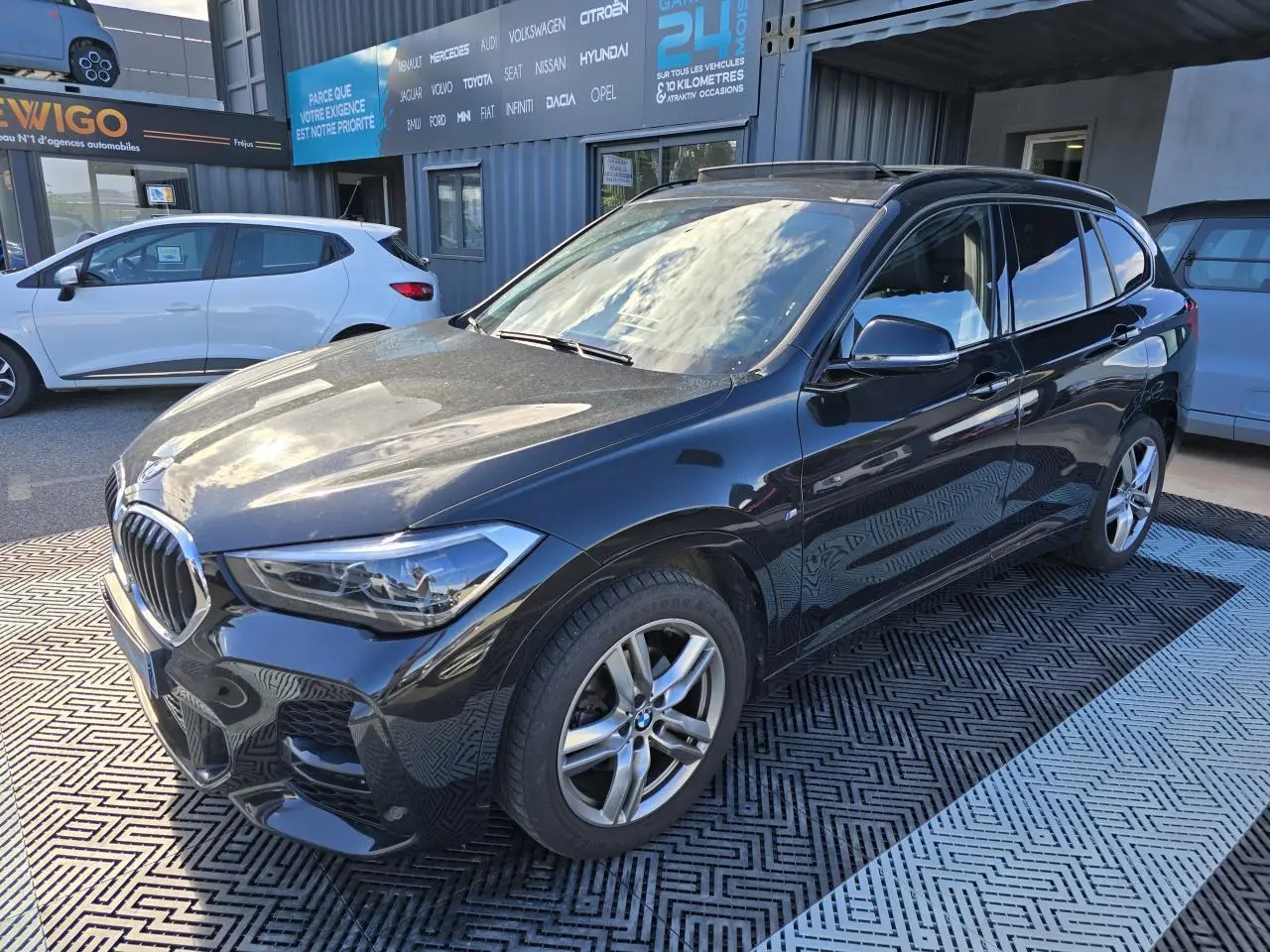 BMW X1 F48 noir saphir métal en 3/4 avant droit avec jantes alliage et calandre chromée brillante