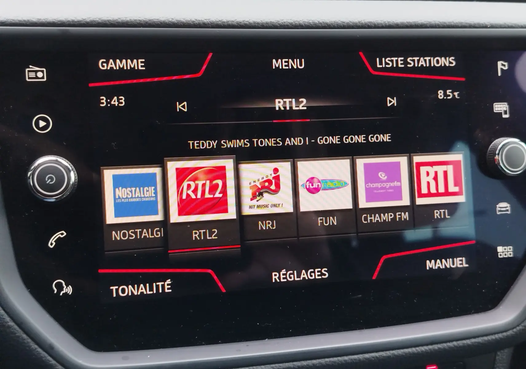 Écran tactile central de la SEAT Arona 2020 affichant les stations radio avec interface noire et détails rouges.