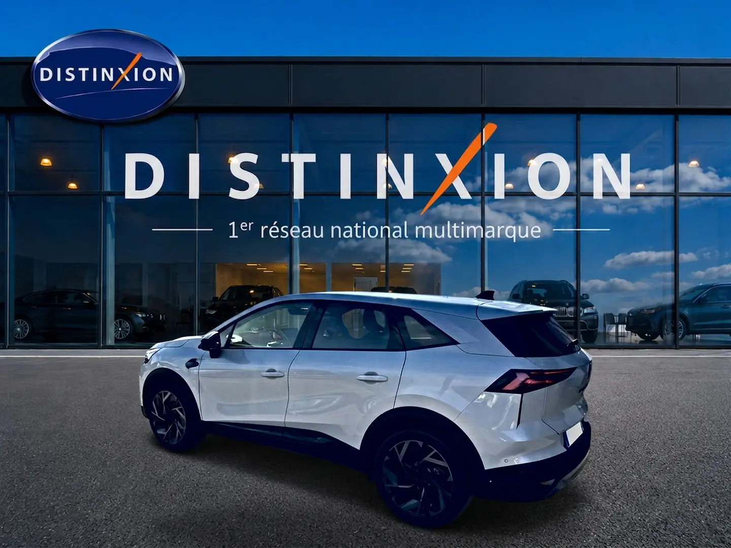 Renault Symbioz blanc nacré vu de profil côté gauche, avec jantes noires et feux arrière LED distinctifs.