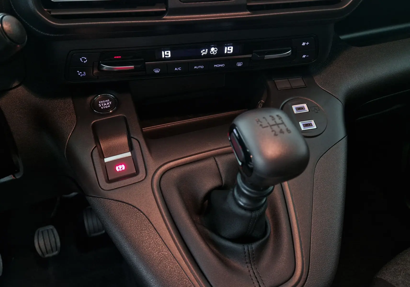 Gros plan sur la console centrale noire de l'Opel Combo Life 2025 avec levier de vitesse manuel et bouton start/stop.