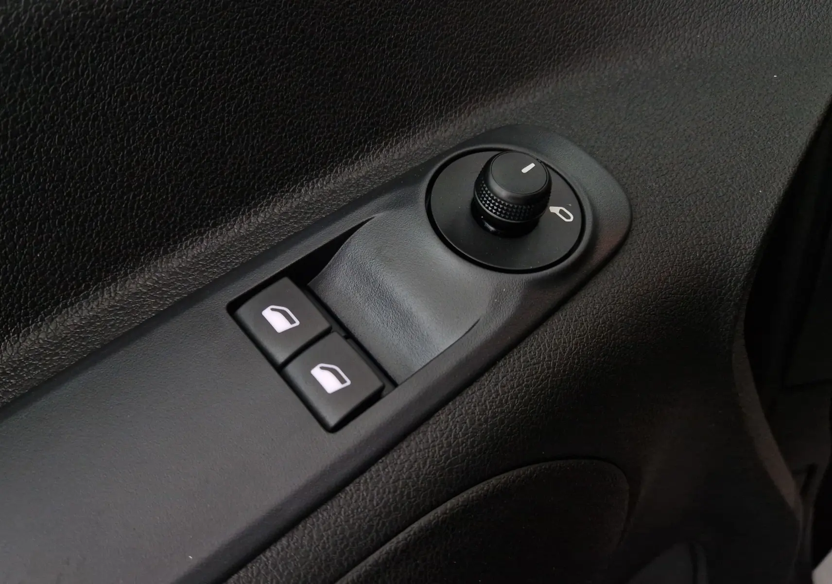Gros plan sur les commandes de réglage des rétroviseurs et des vitres côté conducteur de l'Opel Combo Life bleu Kiama.