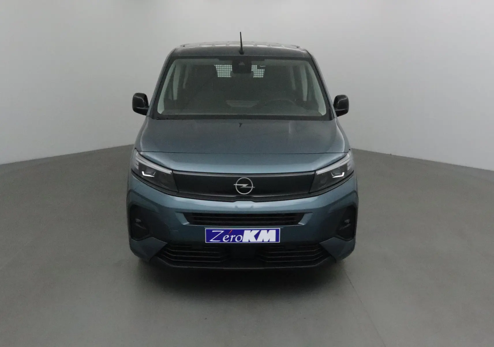 Vue frontale d'un Opel Combo Life bleu Kiama avec calandre noire et plaque Zero KM visible.