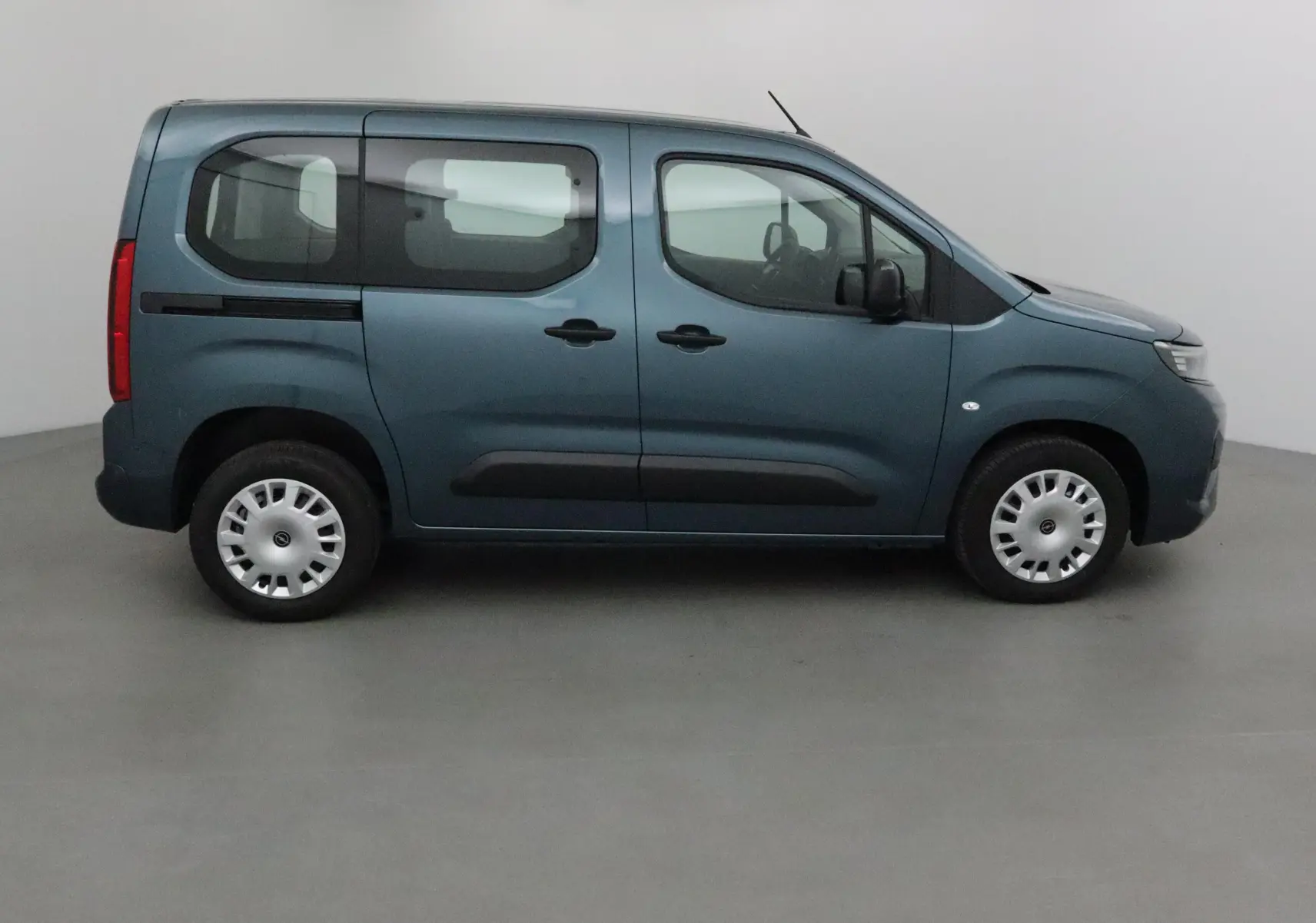 Opel Combo Life bleu Kiama vu de profil côté gauche, avec portes coulissantes et vitres teintées arrière.