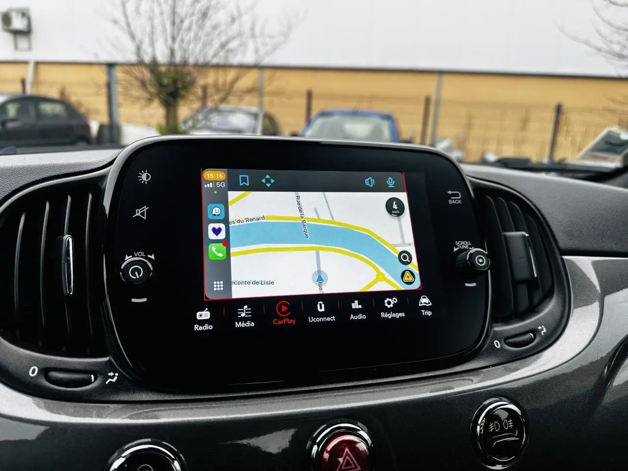 Écran tactile central avec navigation active dans l’habitacle gris foncé d’une Fiat 500 2023, vue de face.