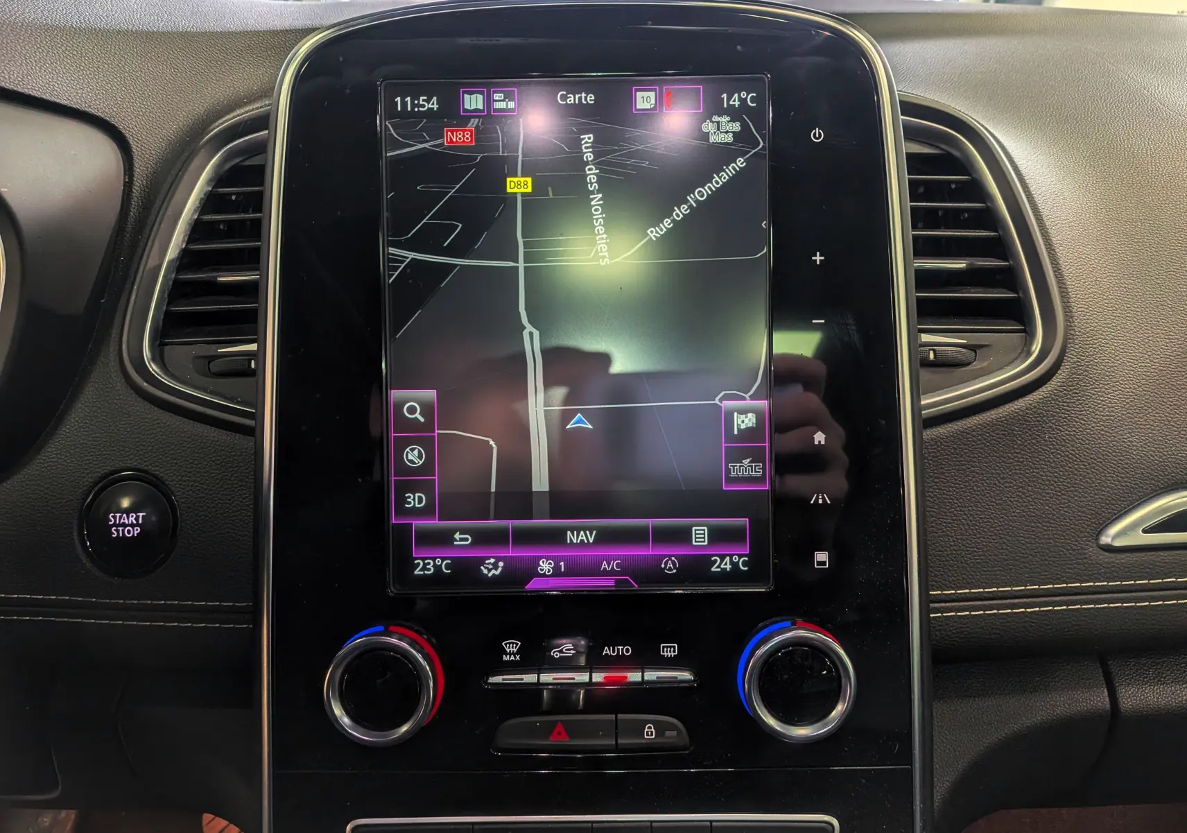 Vue intérieure du tableau de bord du Renault Scénic IV avec écran tactile de navigation et commandes climatisation.