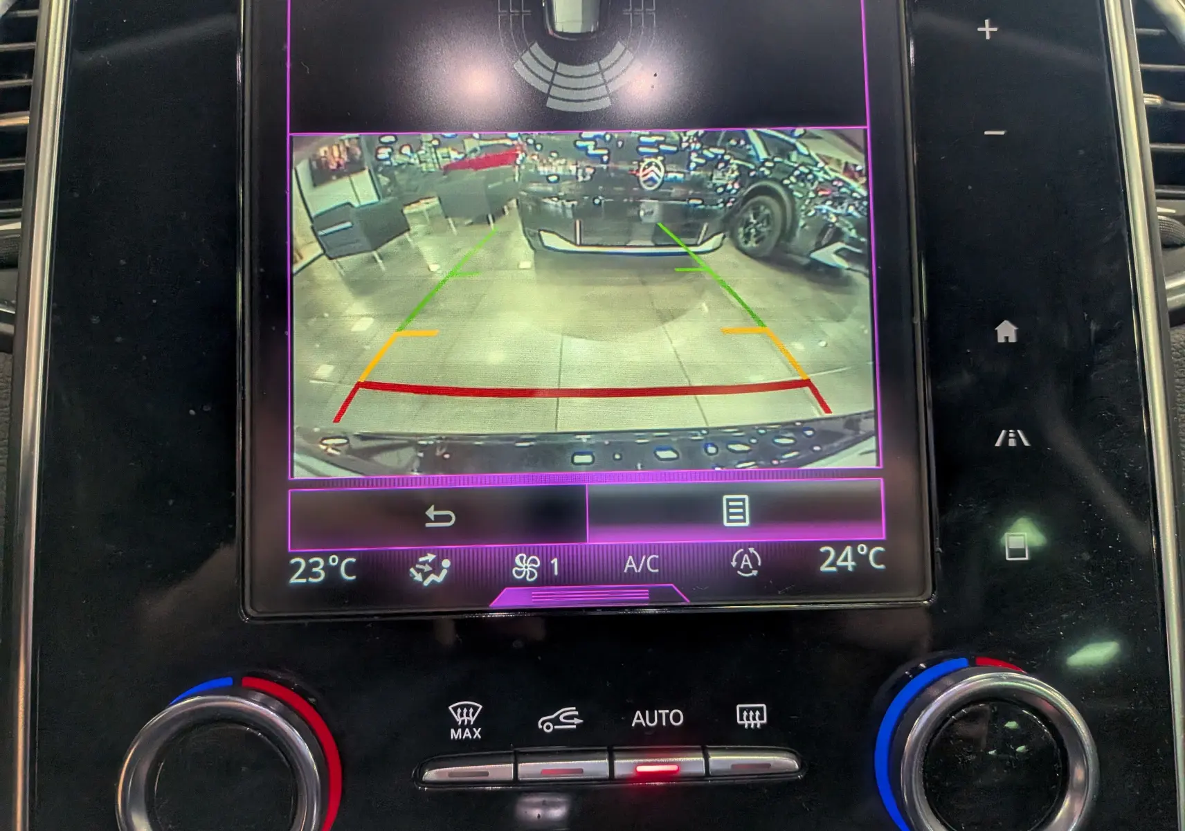 Écran central du Renault Scénic IV noir étoilé montrant la caméra de recul avec lignes de guidage colorées.