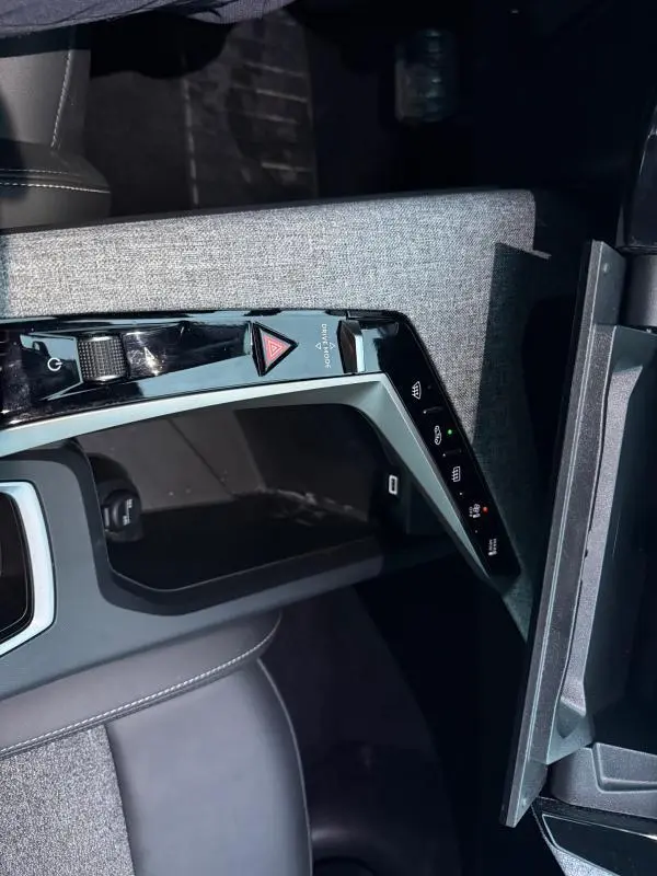 Vue rapprochée de la console centrale du Peugeot 3008 Hybrid 145 e-DCS6 Allure 2025, avec commandes tactiles et finition tissu grise.