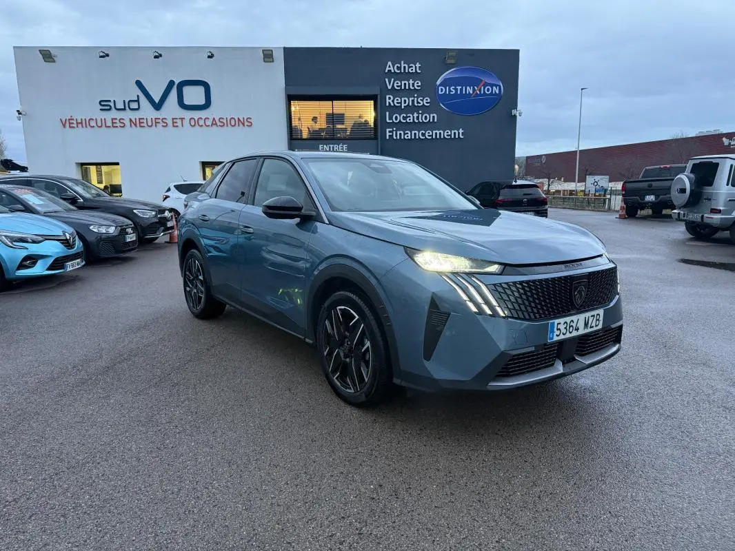 Peugeot 3008 Hybrid bleu vue 3/4 avant droit, feux allumés, jantes alliage 19 pouces, stationné devant un concessionnaire.