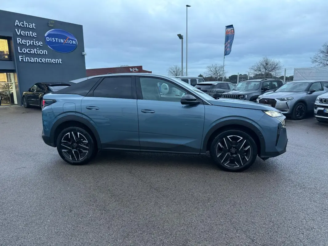 Vue de profil côté gauche d’un Peugeot 3008 Hybrid 145 e-DCS6 Allure bleu avec jantes alliage 19 pouces sur parking.