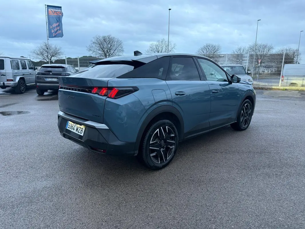 Peugeot 3008 Hybrid bleu en 3/4 arrière droit, jantes alliage 19 pouces et feux arrière LED allumés.