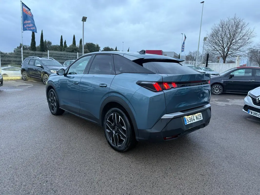 Vue 3/4 arrière droite d’un Peugeot 3008 Hybrid bleu 2025 avec jantes alliage 19 pouces et feux arrière LED distinctifs.