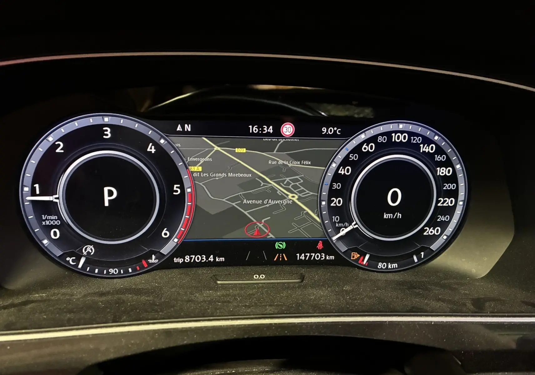 Tableau de bord numérique du Volkswagen Tiguan 2.0 TDI 2017, affichant la navigation et compteurs ronds en blanc et noir.