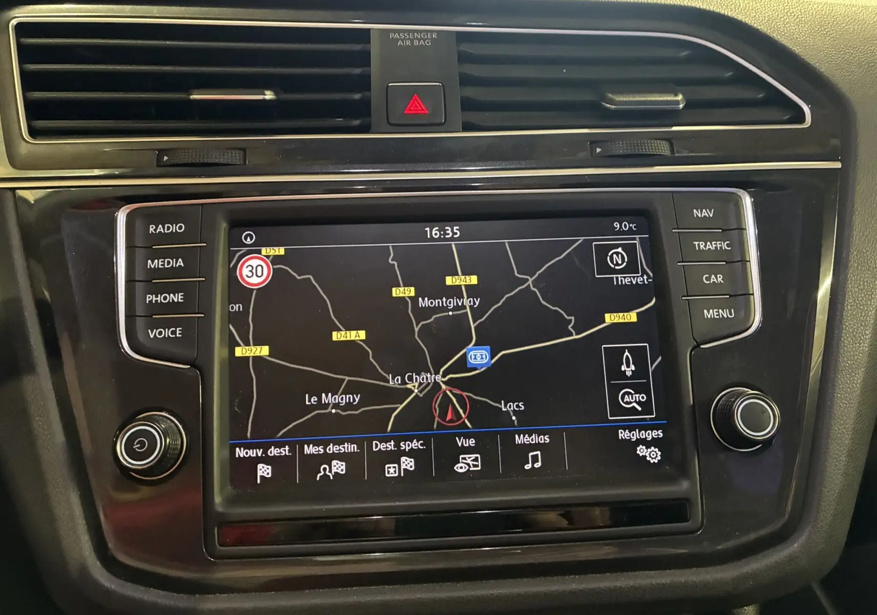 Écran tactile central du Volkswagen Tiguan 2017 gris, affichant la navigation GPS avec commandes autour.