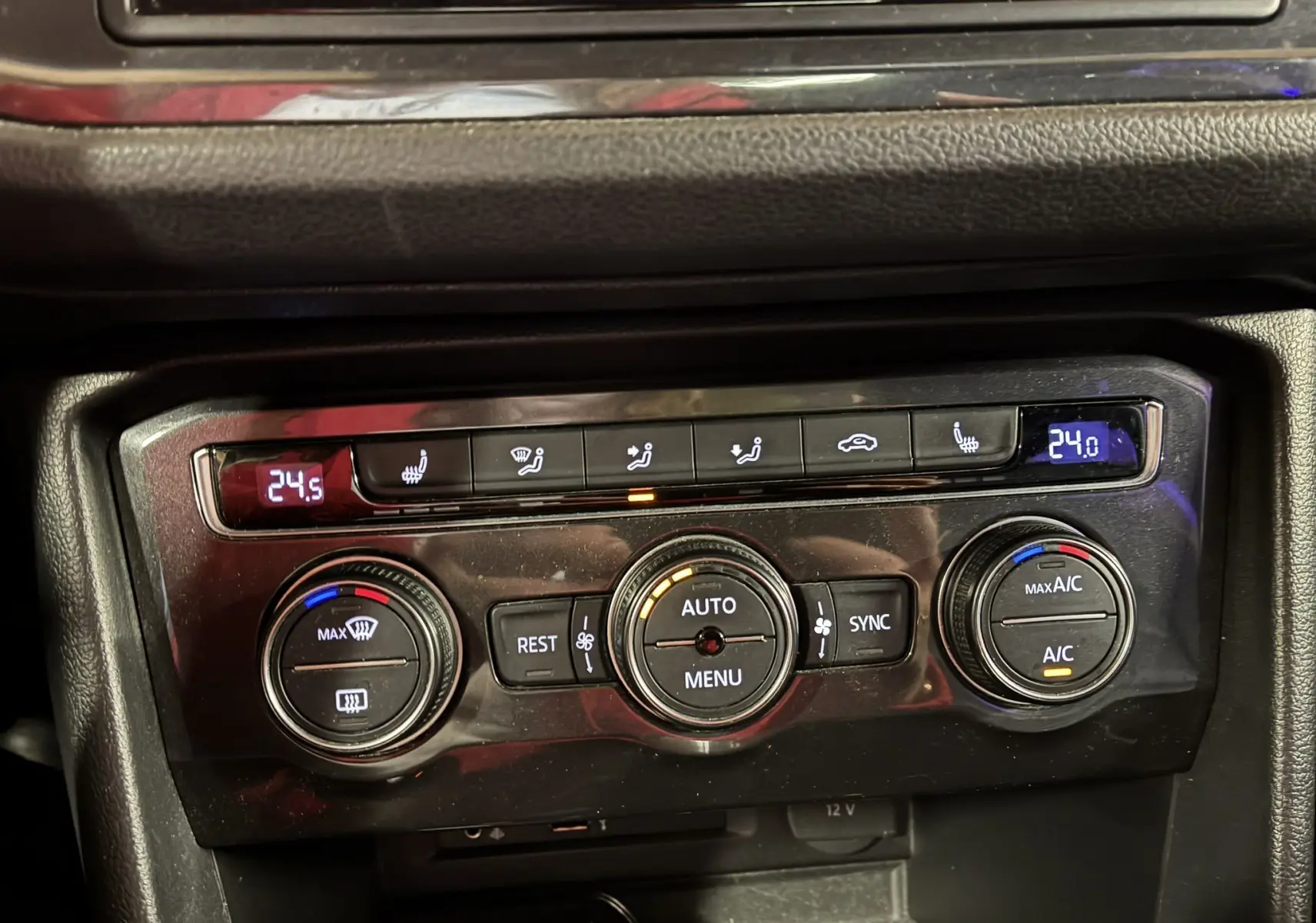 Vue rapprochée de la console centrale du Volkswagen Tiguan 2017, montrant les commandes de climatisation et sièges chauffants.