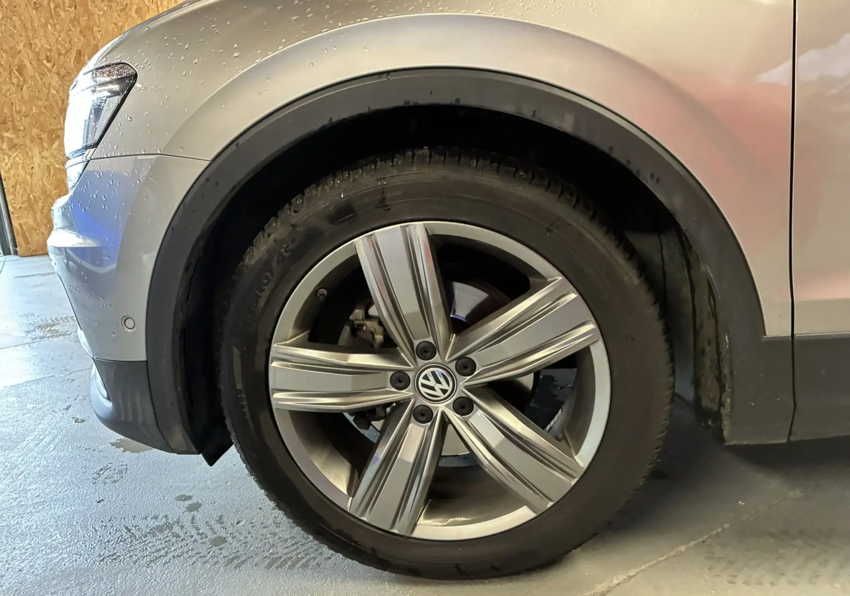 Gros plan sur la roue avant gauche gris métallisé d’un Volkswagen Tiguan 2.0 TDI 150 Carat avec jante alliage 19 pouces.