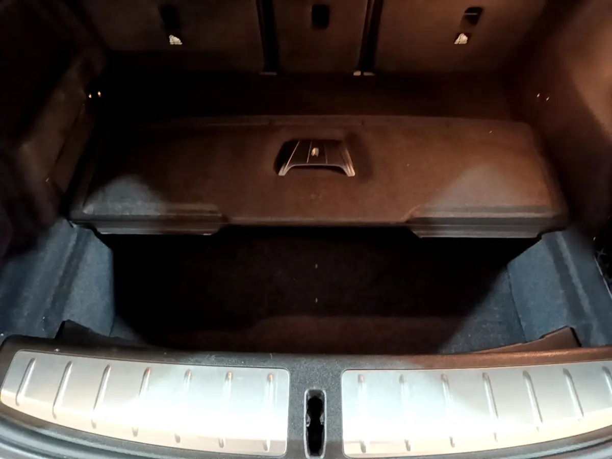 Coffre ouvert vu de dessus d’un BMW X2 gris foncé avec seuil de chargement en métal brossé.