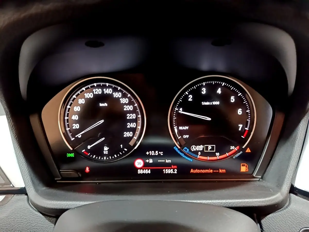 Tableau de bord BMW X2 sDrive18i 2021, vue frontale sur compteur vitesse et compte-tours lumineux.