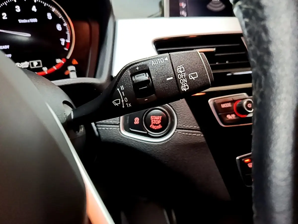 Gros plan sur la commande d’essuie-glace et le bouton start/stop du tableau de bord d’une BMW X2 2021.