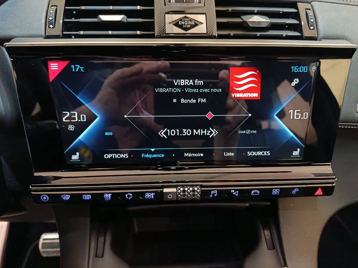 Vue rapprochée de l’écran tactile central noir du DS7 Crossback E-TENSE 4x4 300, affichant la radio FM et la climatisation.