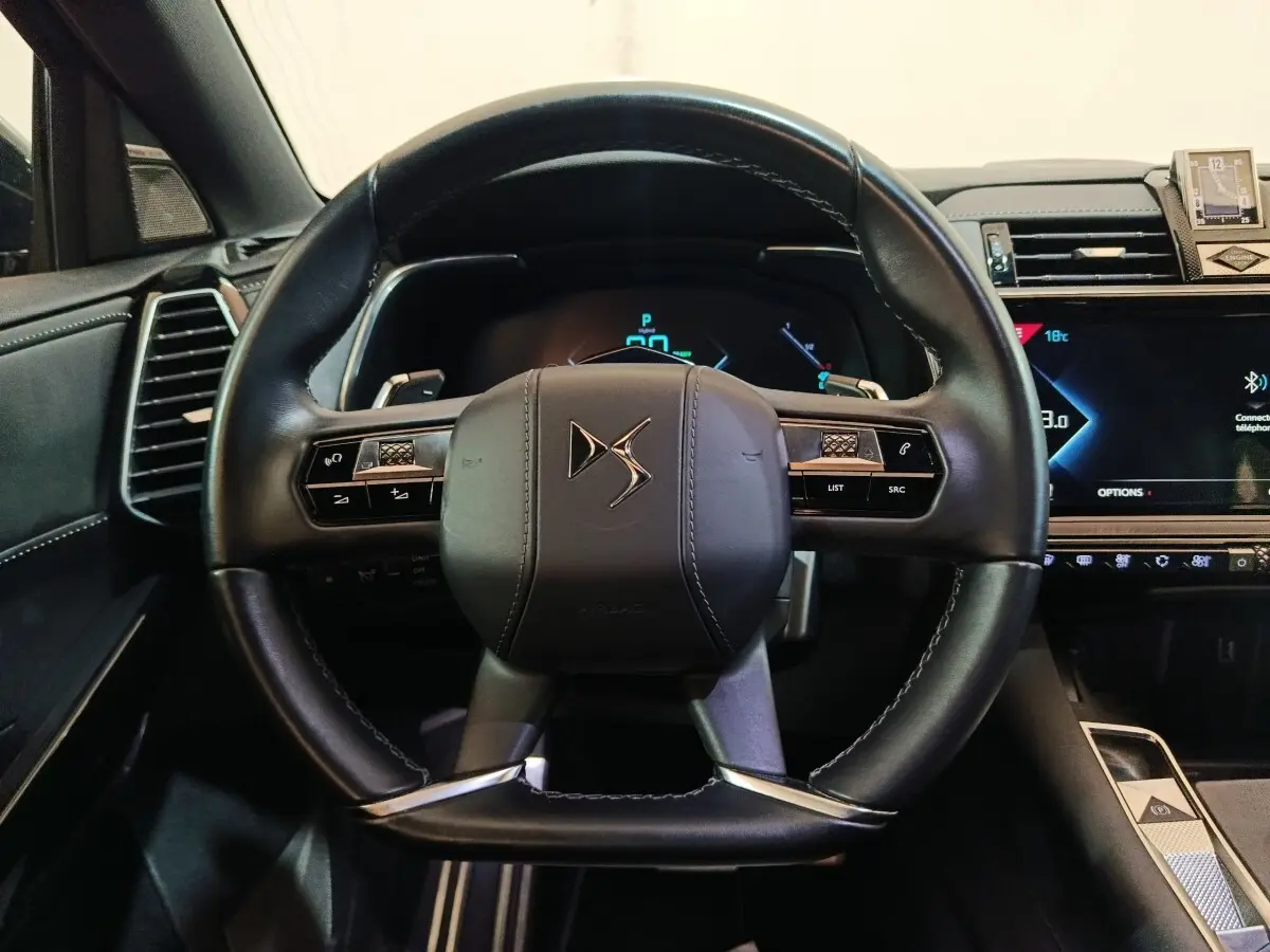 Vue rapprochée du volant cuir noir DS7 Crossback E-TENSE 4x4 2022 avec tableau de bord digital et commandes intégrées.