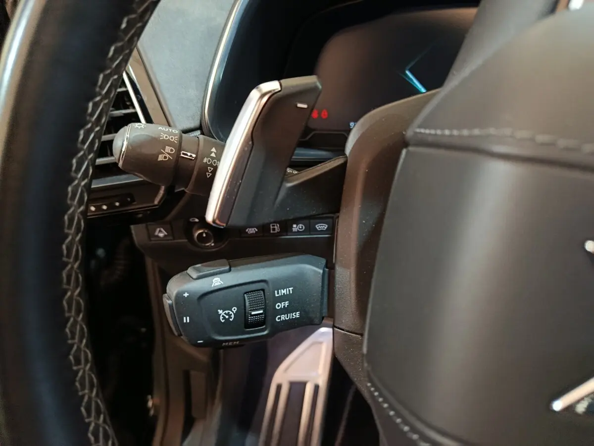 Gros plan sur la commande de régulateur de vitesse au volant cuir noir du DS7 Crossback E-TENSE 2022.