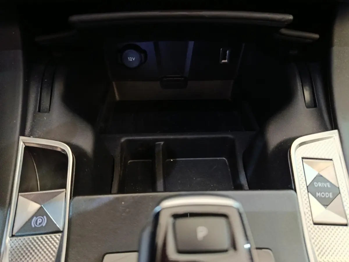 Gros plan sur la console centrale noire du DS7 Crossback E-TENSE avec boutons frein à main et mode de conduite.