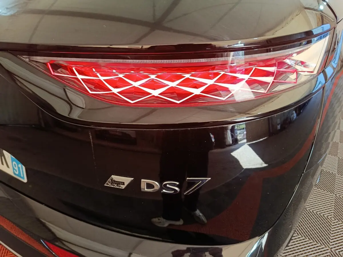 Gros plan sur le feu arrière droit et le logo DS7 noir brillant du SUV DS7 Crossback E-TENSE 4x4 300 LOUVRE 2022.