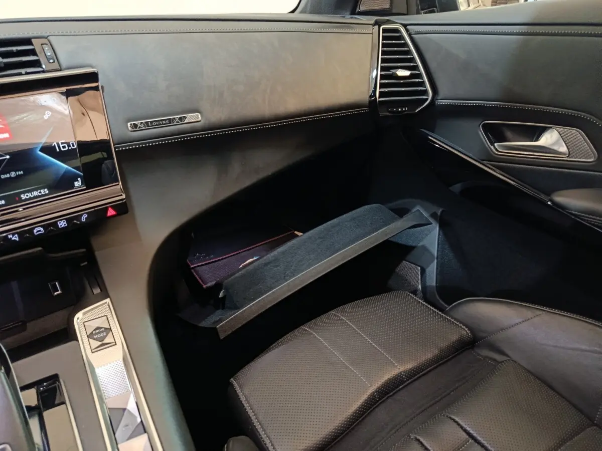 Intérieur noir du DS7 Crossback E-TENSE 4x4 300 Louvre, vue côté passager avec boîte à gants ouverte et tableau de bord.