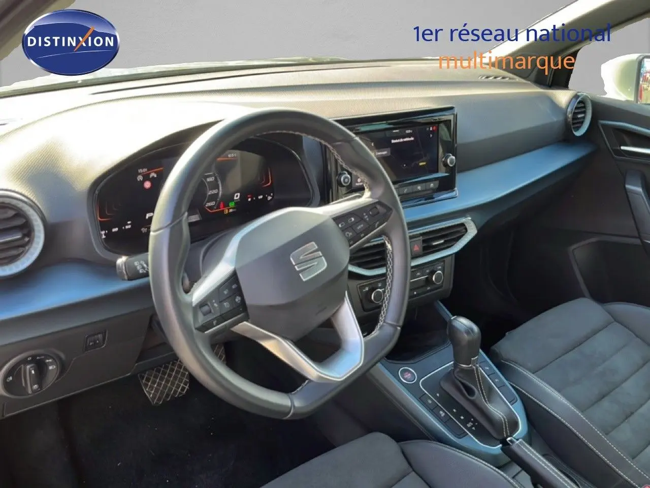 Vue intérieure du poste de conduite du SEAT Arona 2025, volant cuir multifonction et tableau de bord numérique.