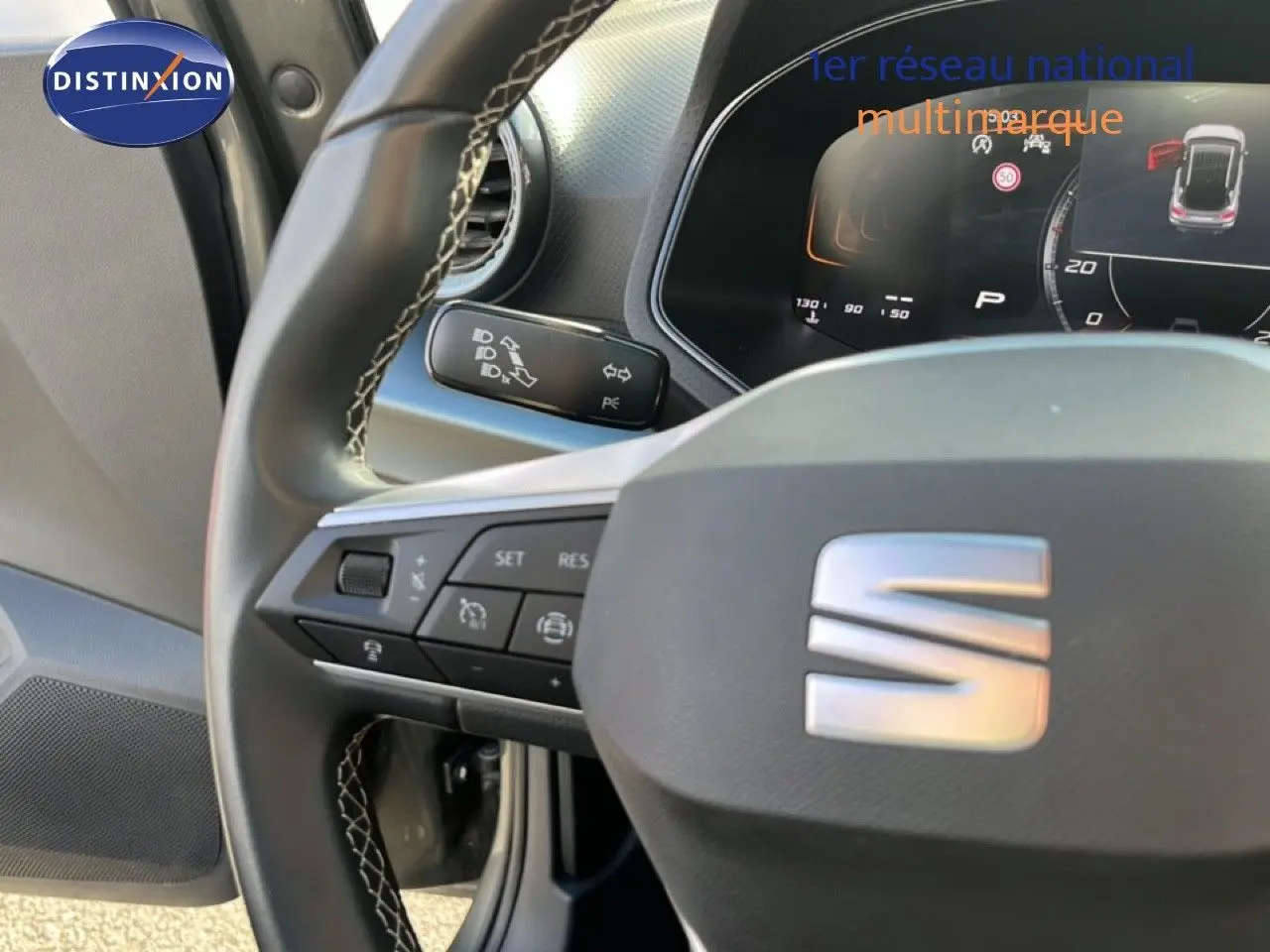 Gros plan sur le volant et le tableau de bord digital d’un SEAT Arona 2025, intérieur noir avec finitions modernes.