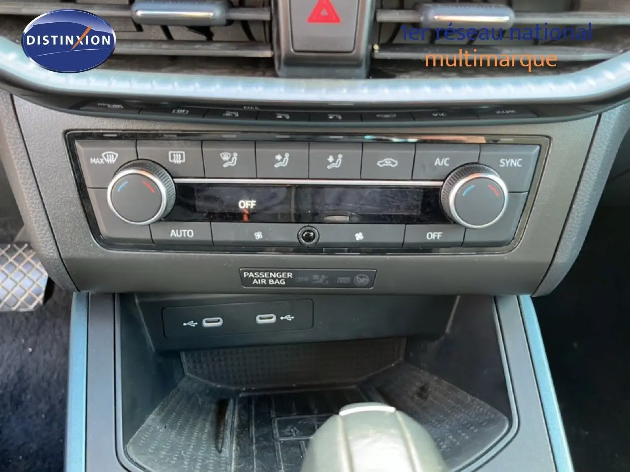 Vue rapprochée de la console centrale du SEAT Arona 2025, montrant les commandes de climatisation et ports USB.