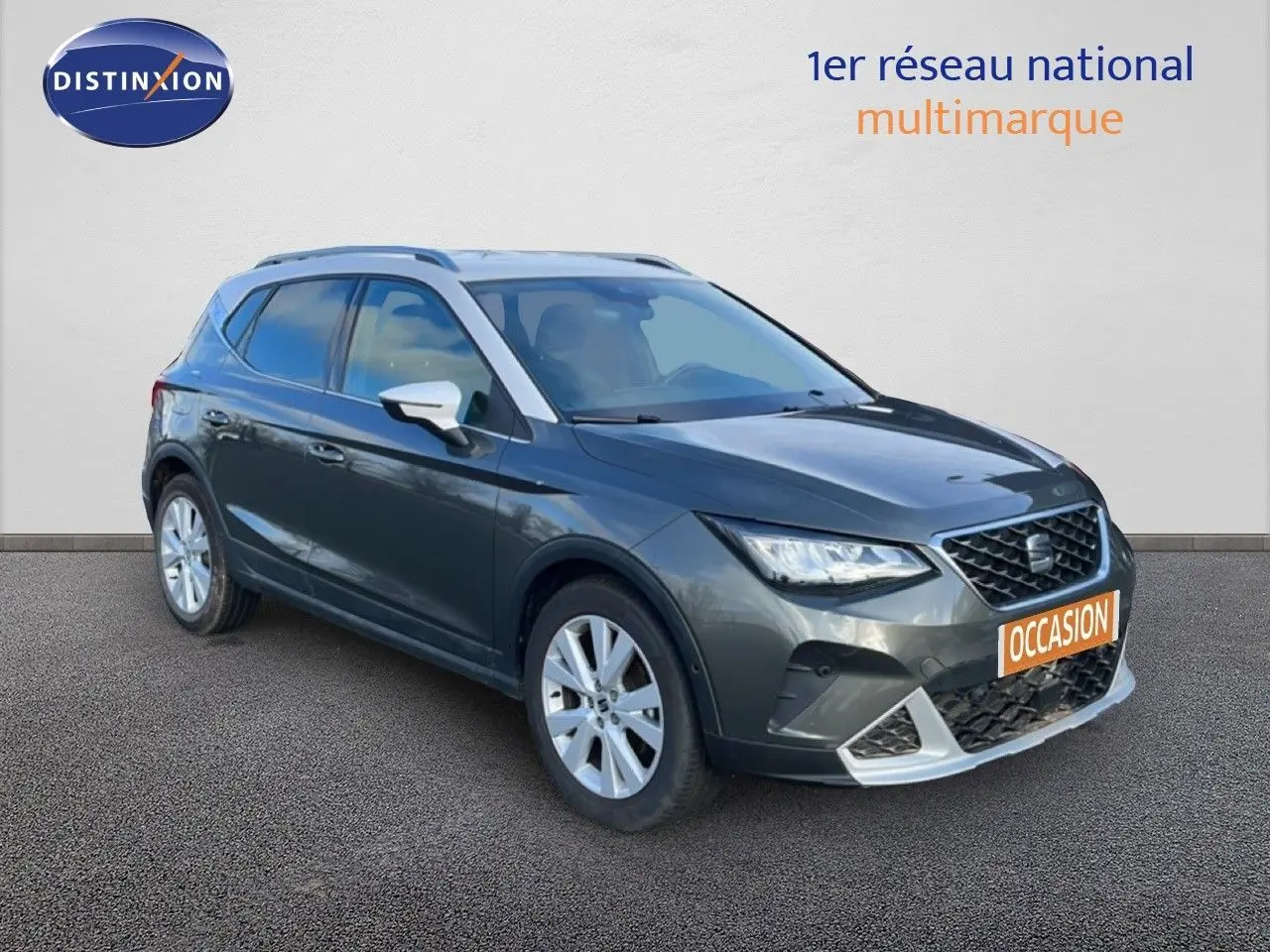 SEAT Arona gris magnétique vue 3/4 avant droit avec toit noir et jantes alliage, en extérieur sur sol goudronné.